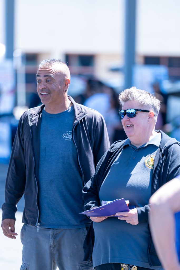 Two staff members smiling at a health and wellness fair at CCWF in Chowchilla, California, CDCR.