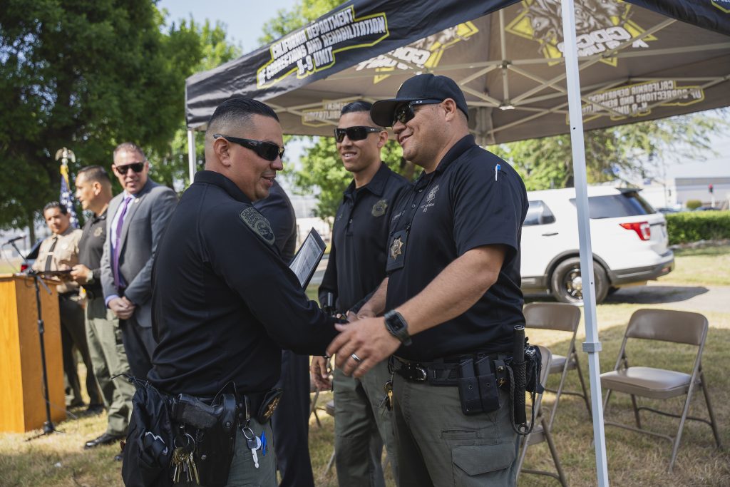 Handshaking at the CIM ceremony honoring contraband-sniffing K-9s.