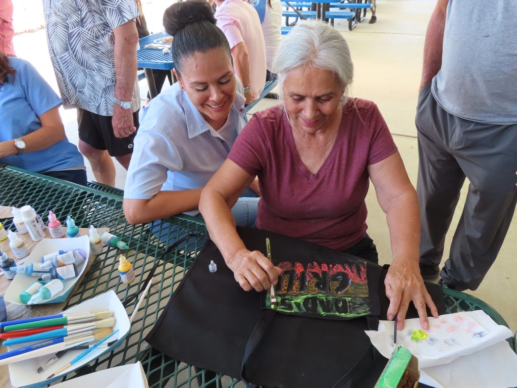 Two people decorate an apron during Father's Day visiting at California Institution for Women in Corona.
