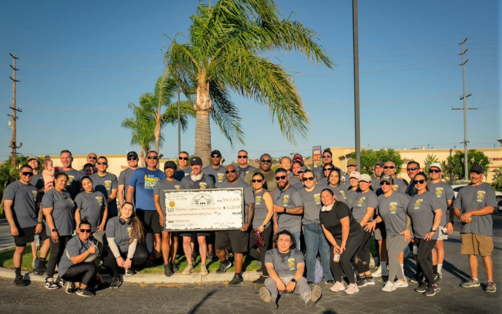 Group photo with oversized check of California Rehabilitation Center at Norco staff after the Law Enforcement Torch Run benefiting Special Olympics Southern California.