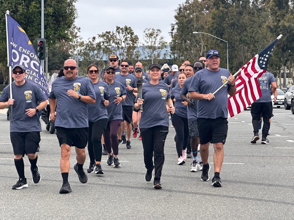 Southern Region Division of Adult Parole Operations runners carry flags during the Law Enforcement Torch Run benefitting the Special Olympics Southern California.