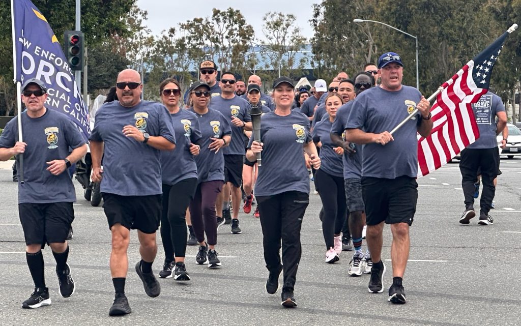 Southern Region Division of Adult Parole Operations runners carry flags during the Law Enforcement Torch Run benefitting the Special Olympics Southern California.