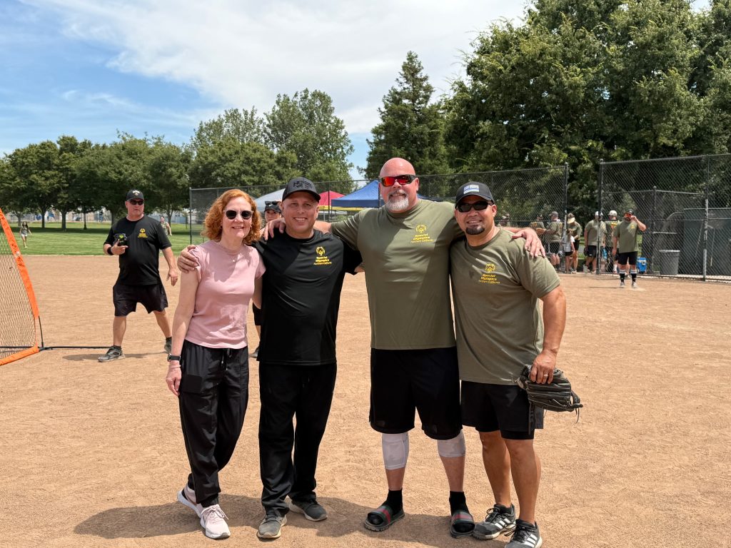 Four people at a charity softball game to benefit Special Olympics.