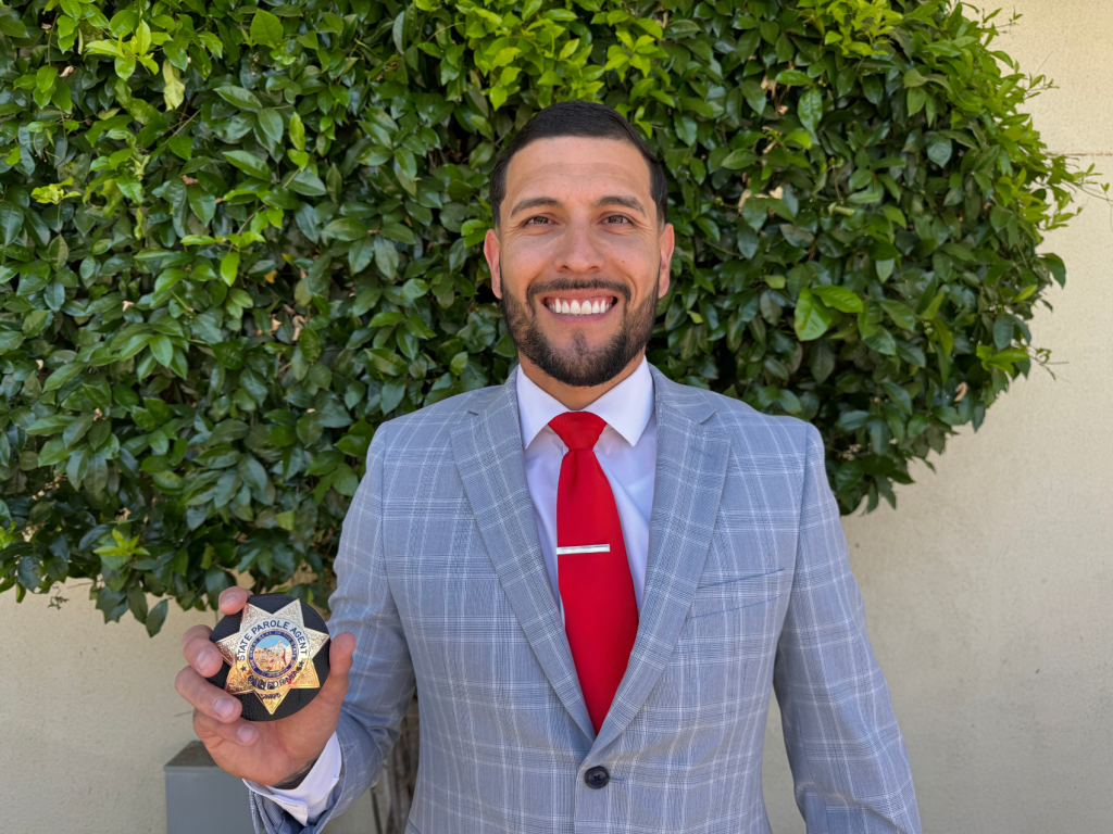 Mendoza holds up his parole agent badge.