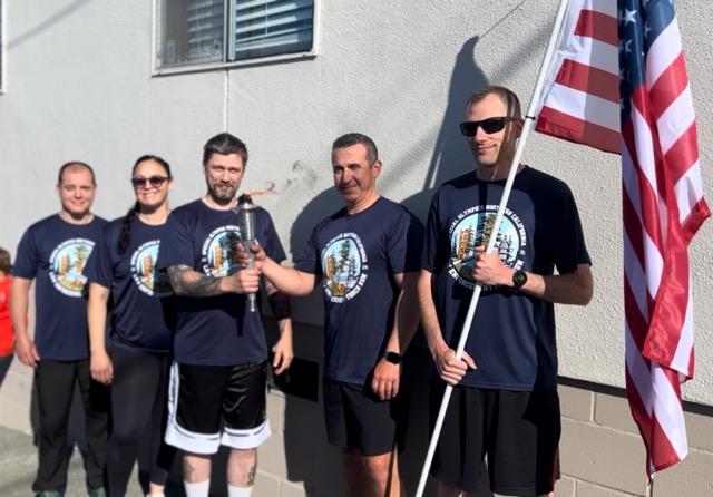 CDCR Pelican Bay State Prison staff volunteers and CHP runners hold the Law Enforcement Torch Run Flame of Hope.
