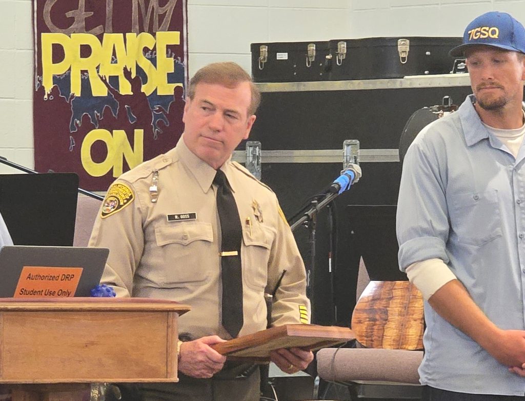 Officer Goss with a plaque in recognition of his retirement from San Quentin. 