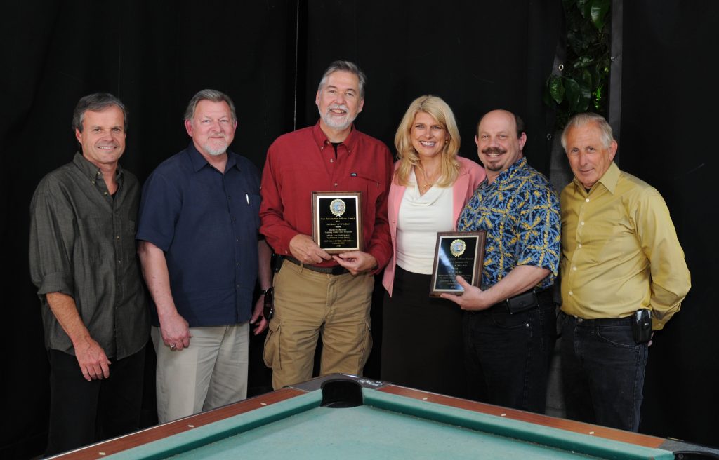 Sabicer holding an award with other staff members.