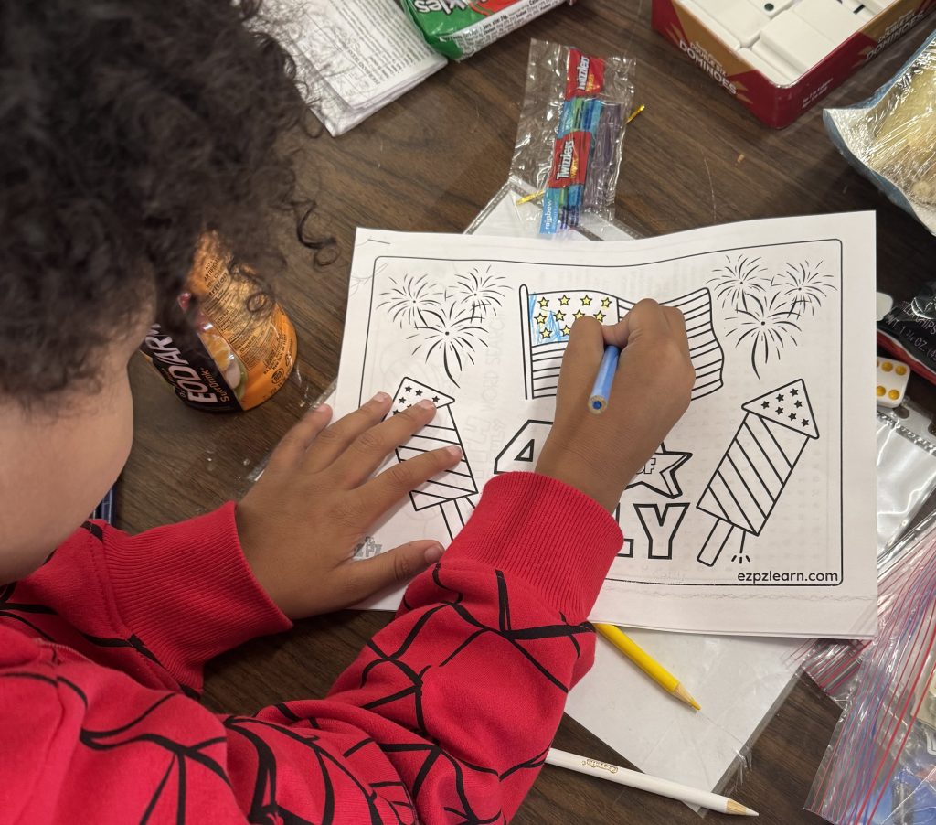 A child colors a flag and rocket at CCI visiting.