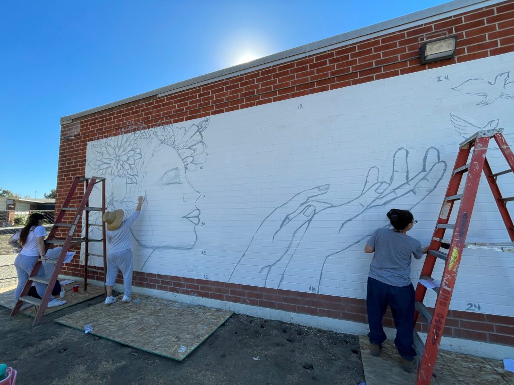 Rough sketch of the mural plan on a blank wall at CIW.