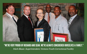 A group of people with 2015 Medal of Valor recipients from the Division of Juvenile Justice at a community reception.