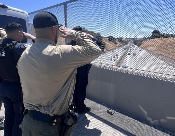 Staff from the Hercules Police Department salute during Agent Byrd's procession to Sacramento.