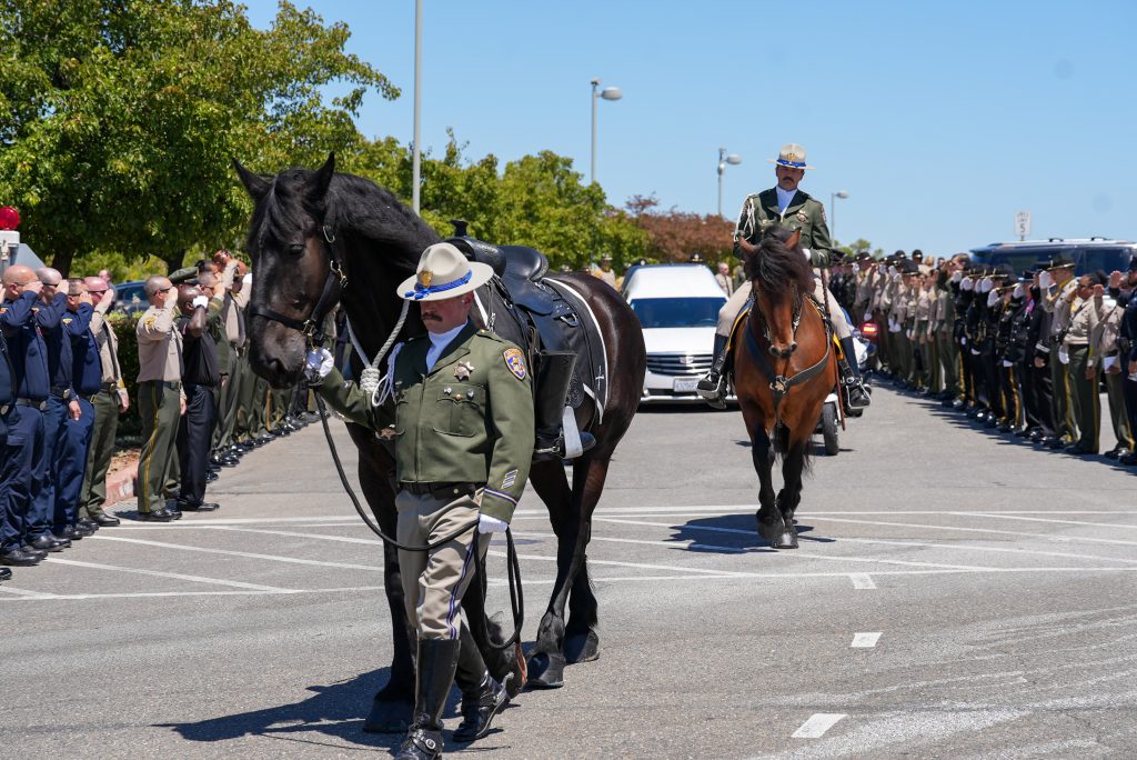 Riderless horse proceeds to the church, followed by the hearse for CDCR Parole Agent Joshua Byrd's memorial service.