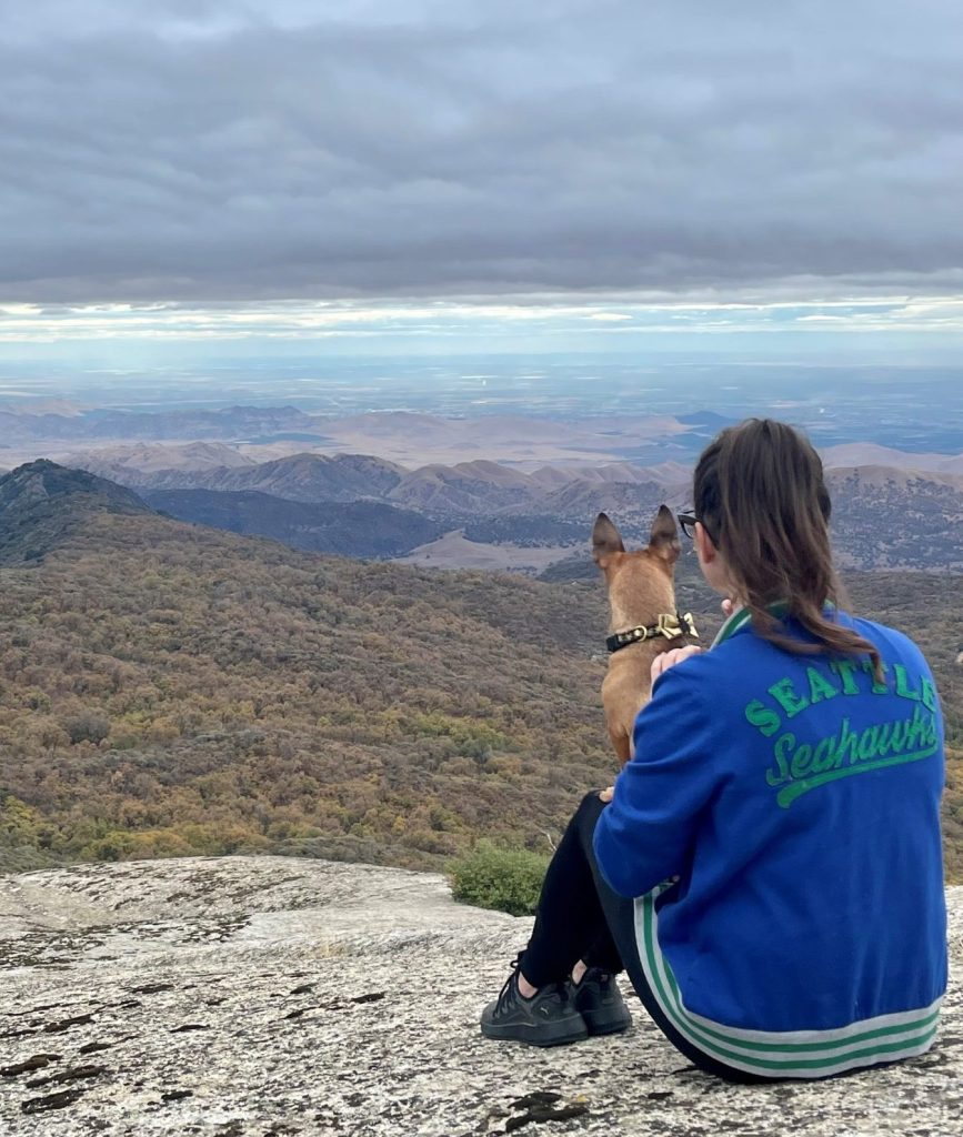 Nicole and her dog overlooking a cliffside