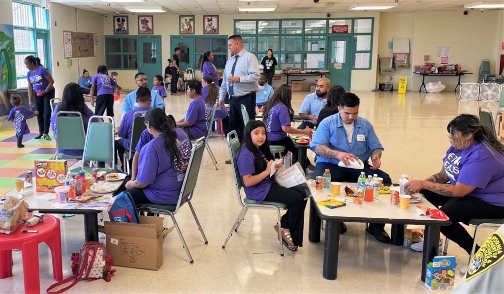 The warden interacts with visiting families during Get on the Bus at the California Substance Abuse Treatment Facility and State Prison at Corcoran.