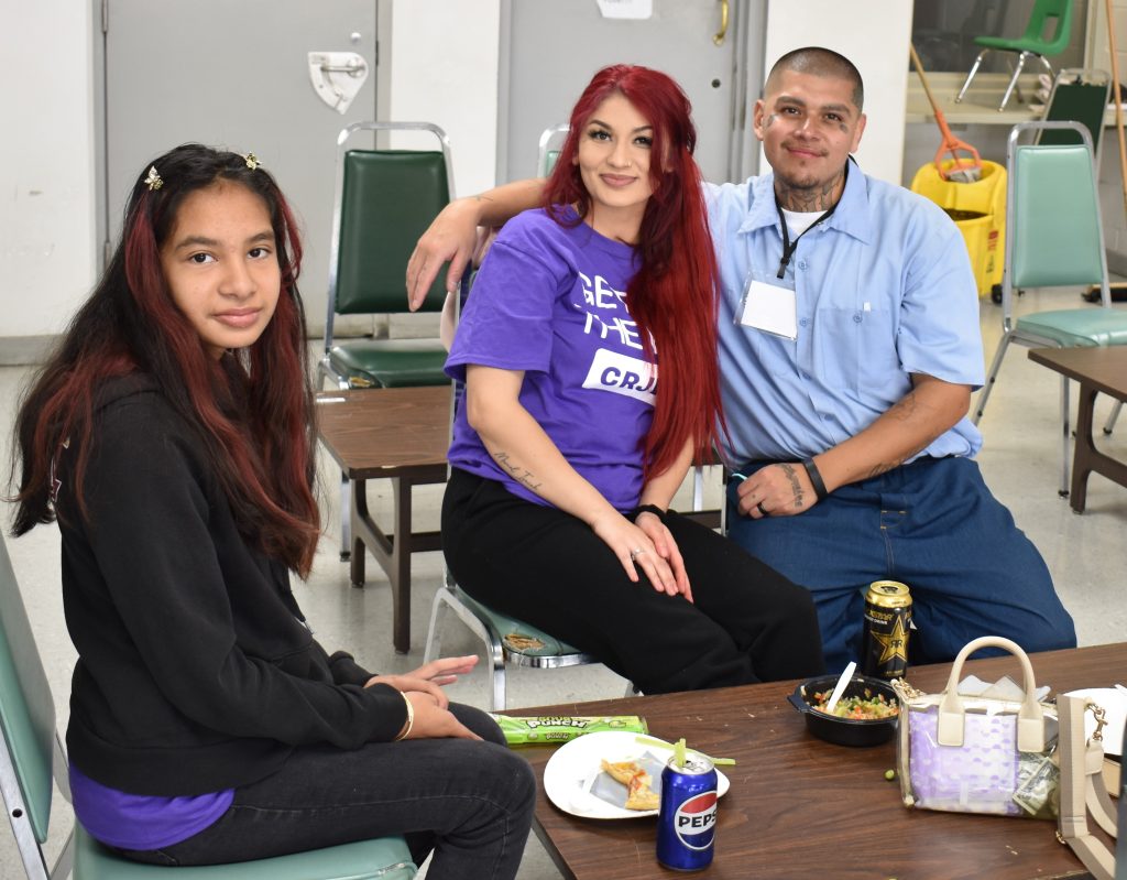 Two people visit an incarcerated person at Salinas Valley State Prison.