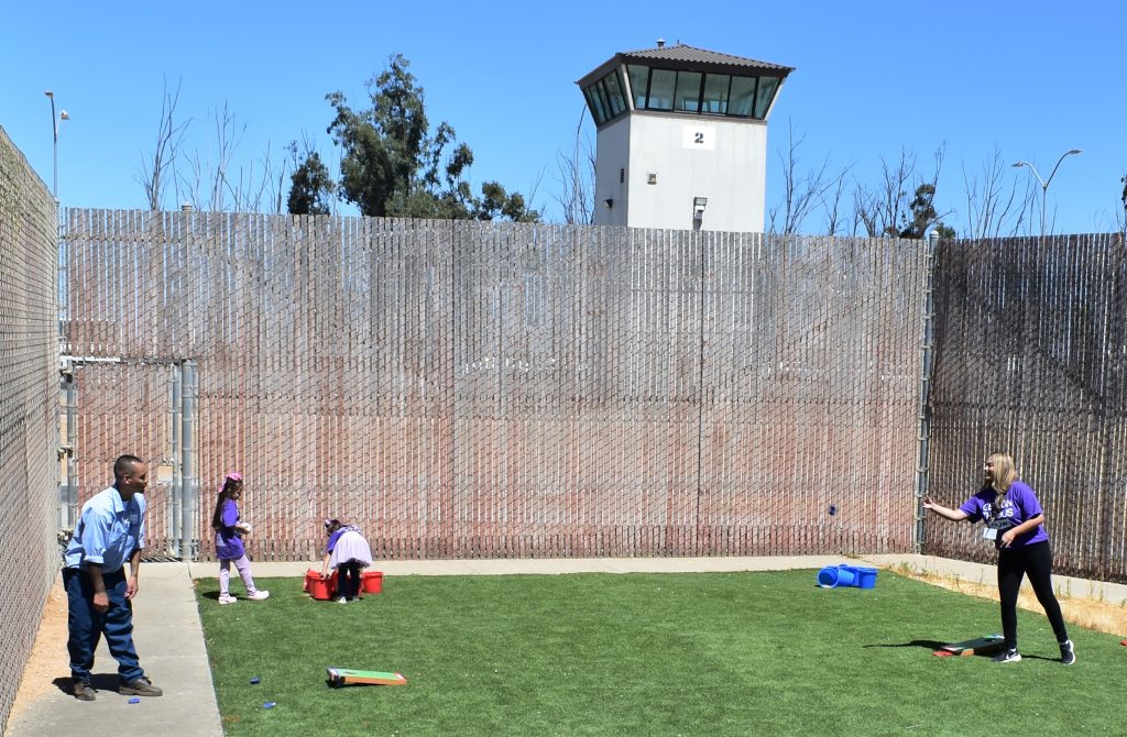 A family plays a game on the grass at Salinas Valley State Prison in Soledad, California.