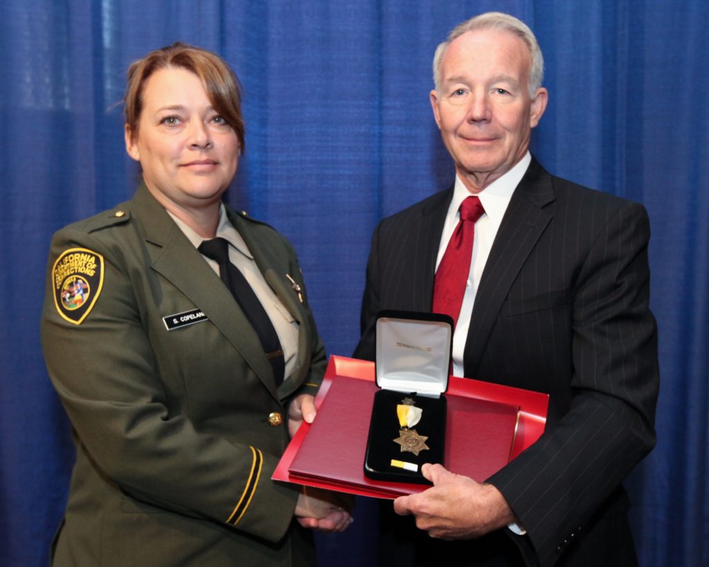 A female officer is awarded the bronze star during the Medal of Valor Employee Recognition Awards ceremony in 2013.