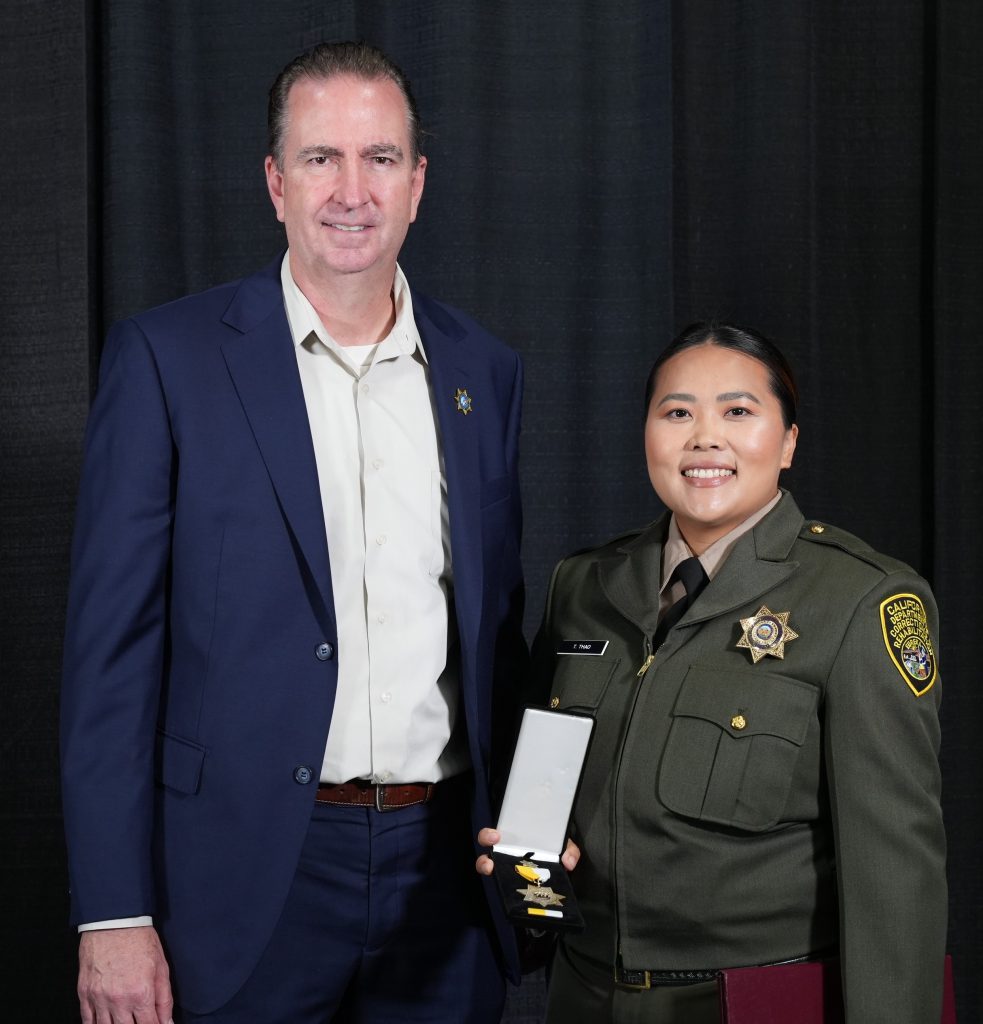 2025 Bronze Star Correctional Officer Teng Thoa with Secretary presenting the award.
