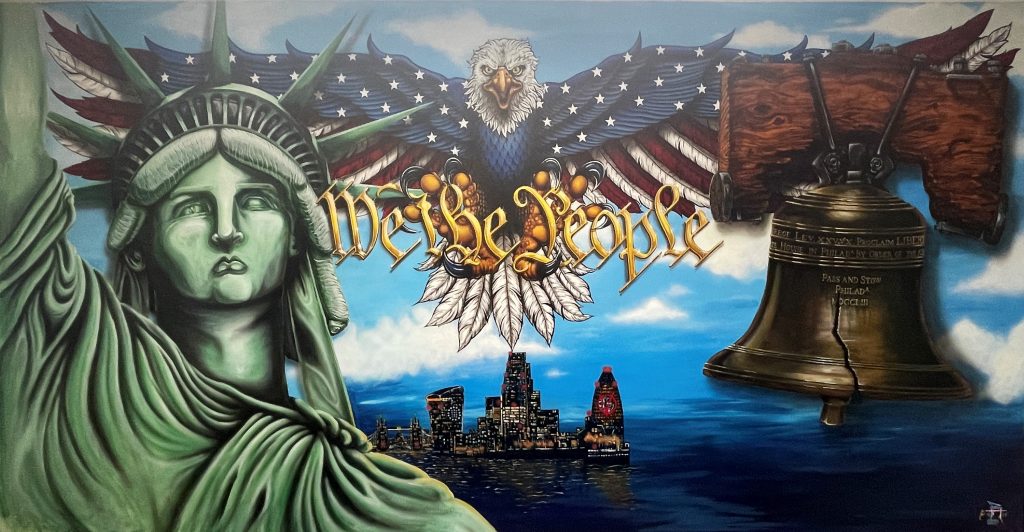 A mural painting showing the Liberty Bell, an American bald eagle, Statue of Liberty and the words "We the People."