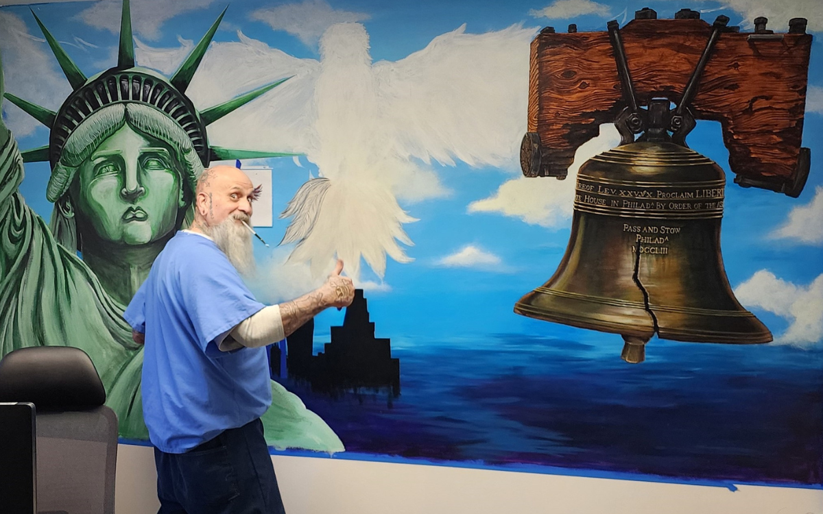Artist paints an office wall at High Desert State Prison in Susanville, Calif.