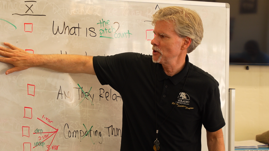 A teacher in front of a whiteboard at a CDCR prison school.