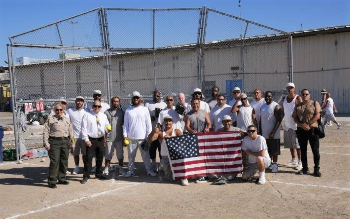 RJ Donovan softball game with players and staff posing with a flag to honor victims of the Sept. 11, 2001, terrorist attacks.