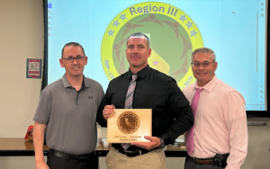 Region III with leaders and a correctional counselor who won a logo contest as part of team-building efforts involving the etire area