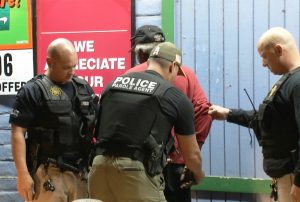 A person is arrested by parole agents during Operation Boo 2017.