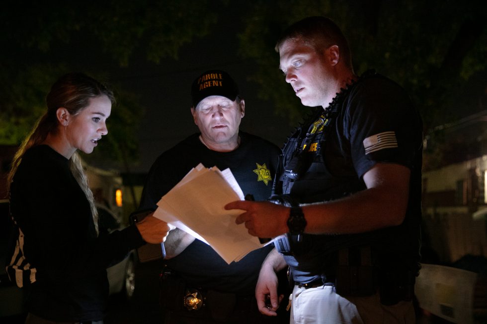 Parole agents check information during compliance checks.