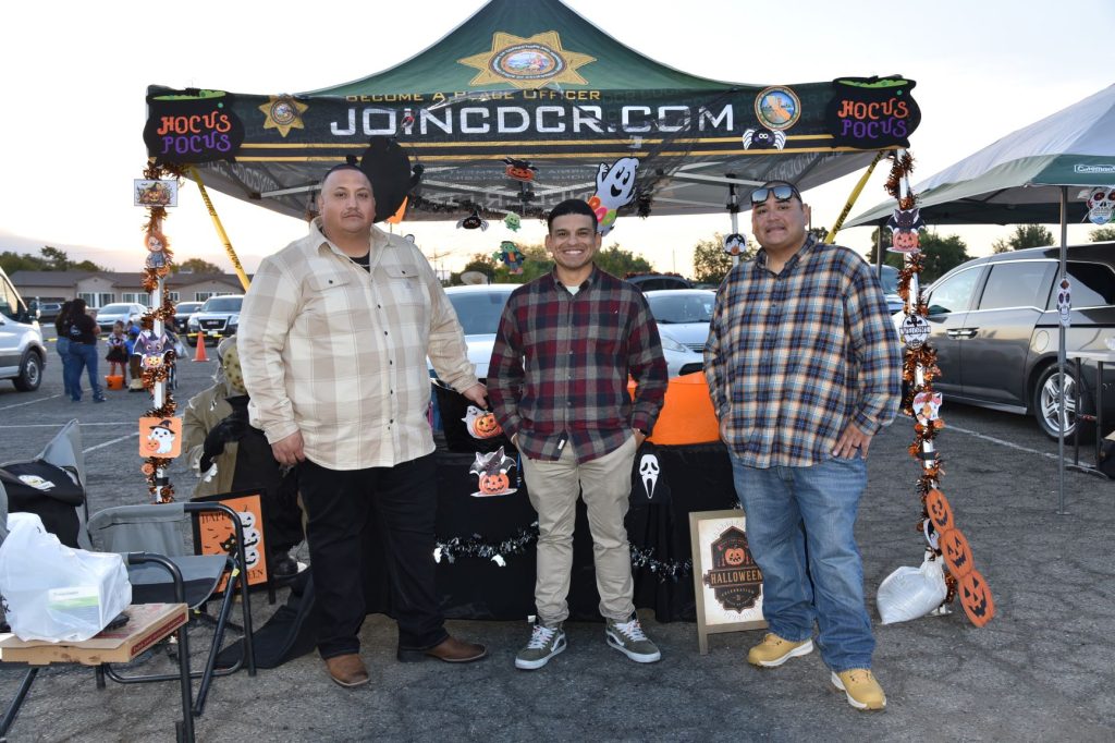 Three staff members from Avenal State Prison at a community Halloween festival.
