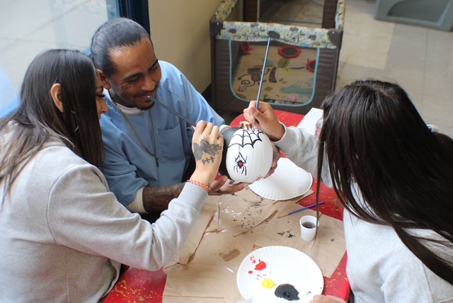 Gomez family paints a pumpkin during Halloween visiting at Mule Creek State Prison in Ione.