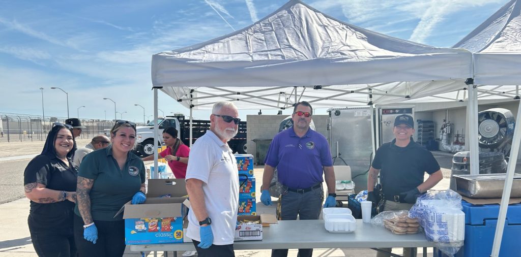 Management and volunteers at Ironwood State Prison prepare to serve food to staff during an appreciation barbecue.
