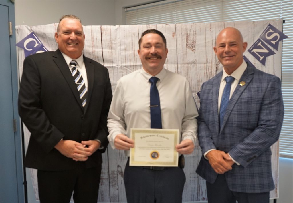 A CDW and the warden with a new correctional counselor II specialist at Kern Valley State Prison.