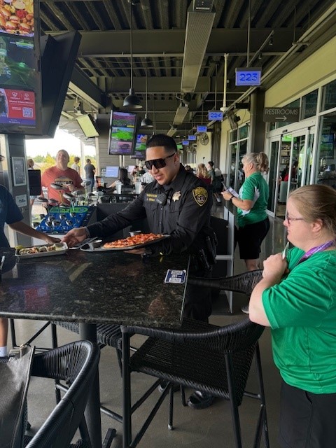 Officer Urrea serving food at Tip A Cop event at Top Golf in Roseville