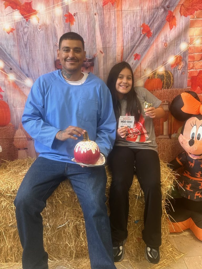 Two people sit on a hay bale at San Quentin.