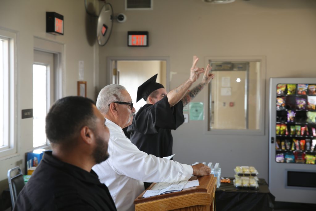 ISUDT graduate celebrating with hands in the air
