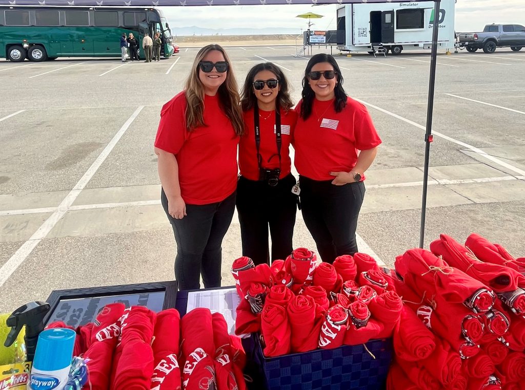 KVSP Employees Association booth with t-shirts and three people standing behind it the table.