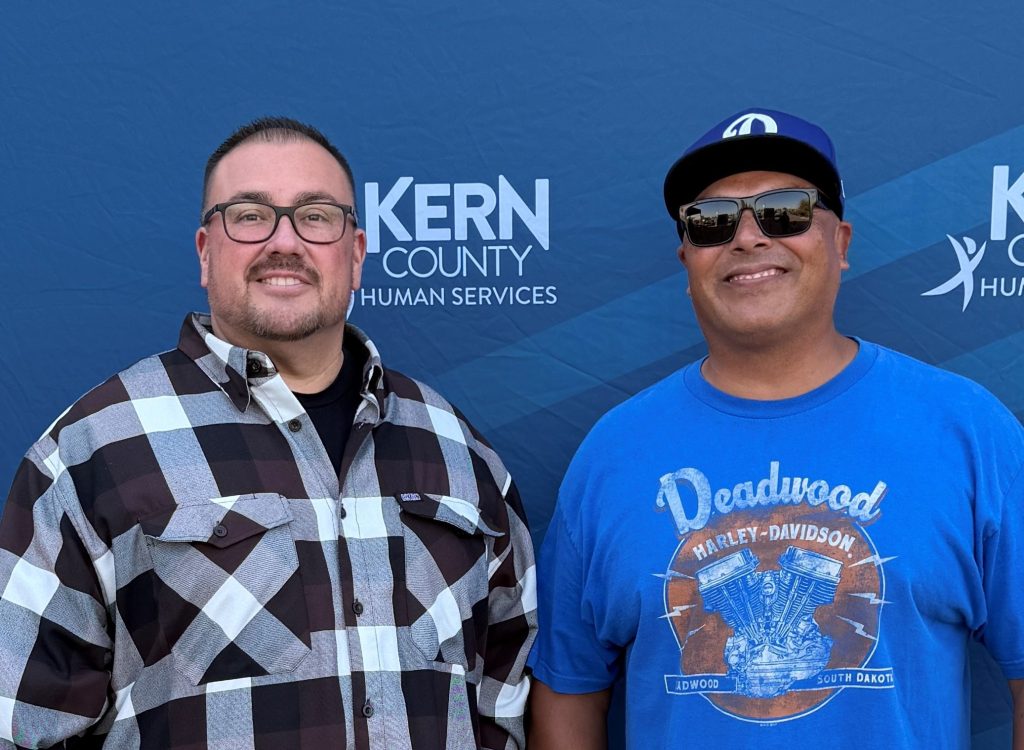 Two people who work for Office of Internal Affairs at the car show and toy drive.