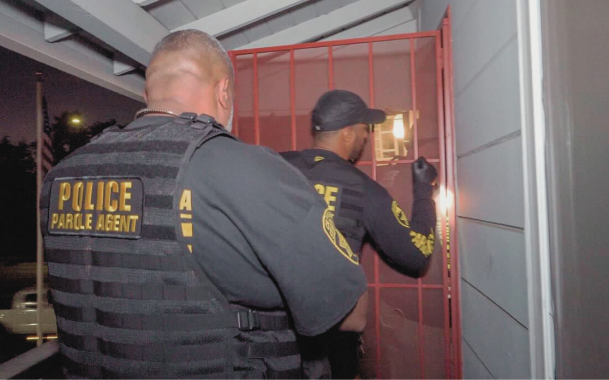 Parole agents knock on a door during a compliance check as part of Operation Boo.