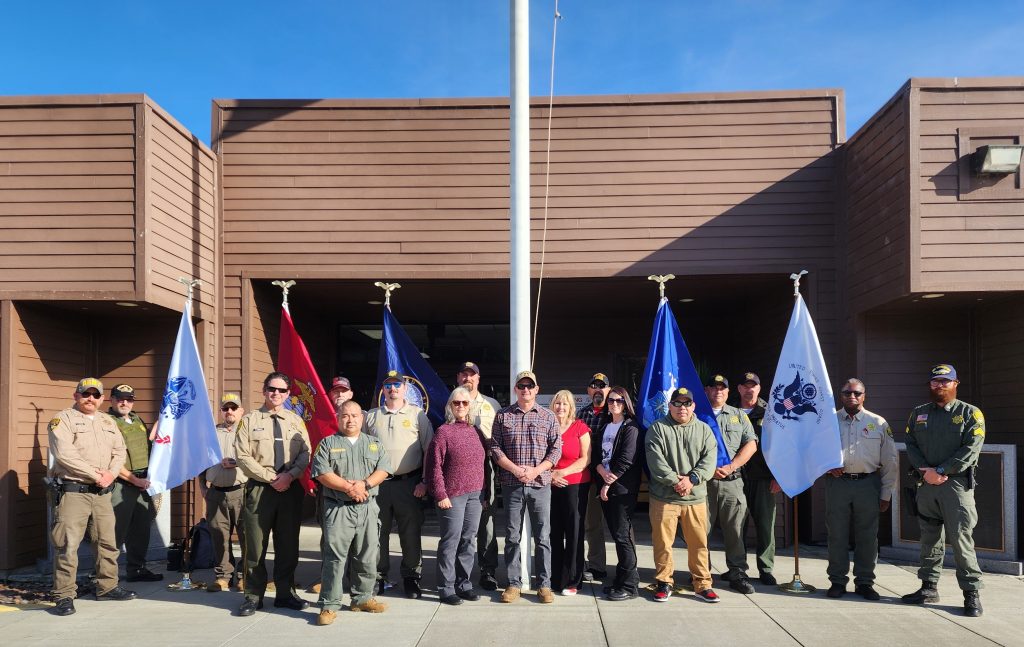 Veteran staff gather at the flagpole at Pelican Bay State Prison.