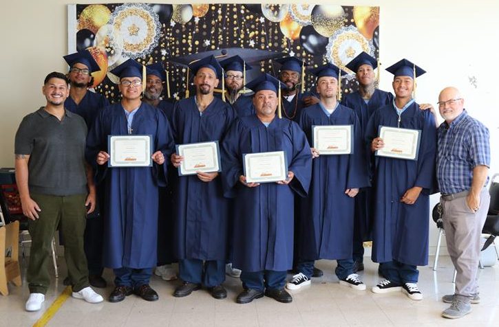 incarcerated graduates posing with their degrees