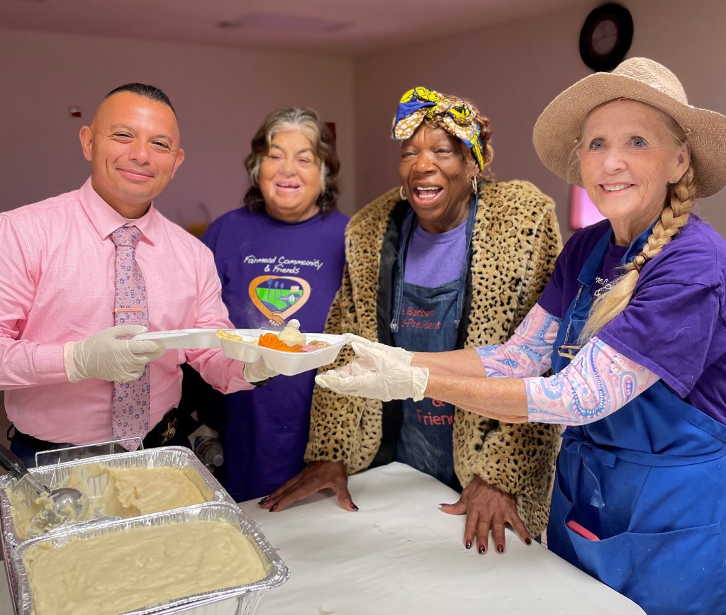 Valley State Prison volunteer and others dishing out food in Fairmead.