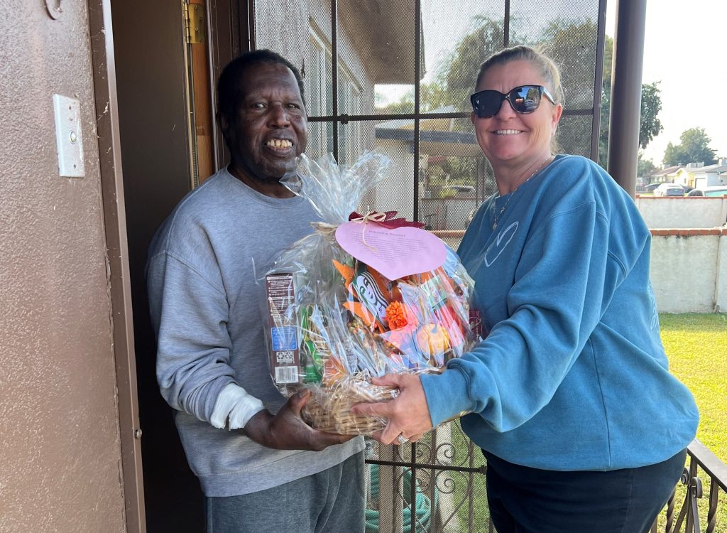 A WSP-RC volunteer delivers a Thanksgiving basket to a man in the community.