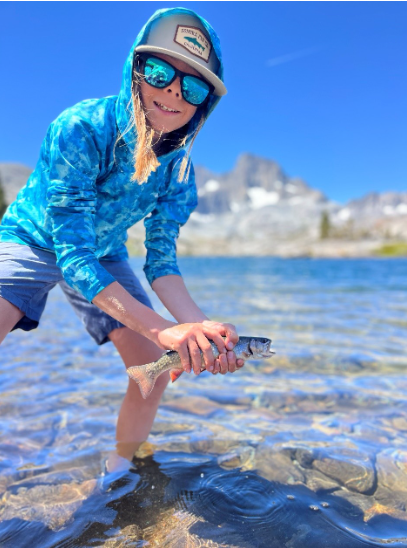 Warren holding a fish from a lake
