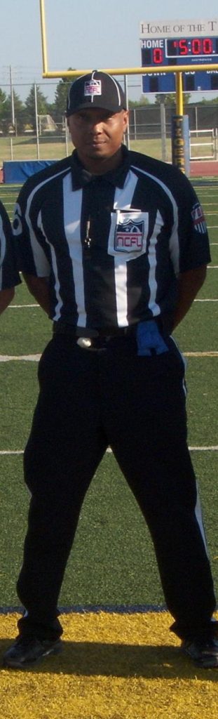 Chief Ombudsman Eric Jones refereeing a football game