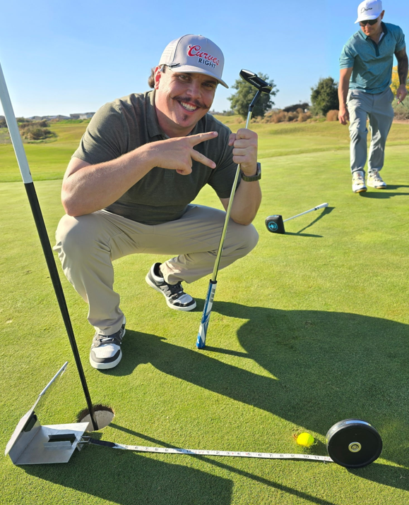 Man playing golf, flashing the camera with a smile and peace sign