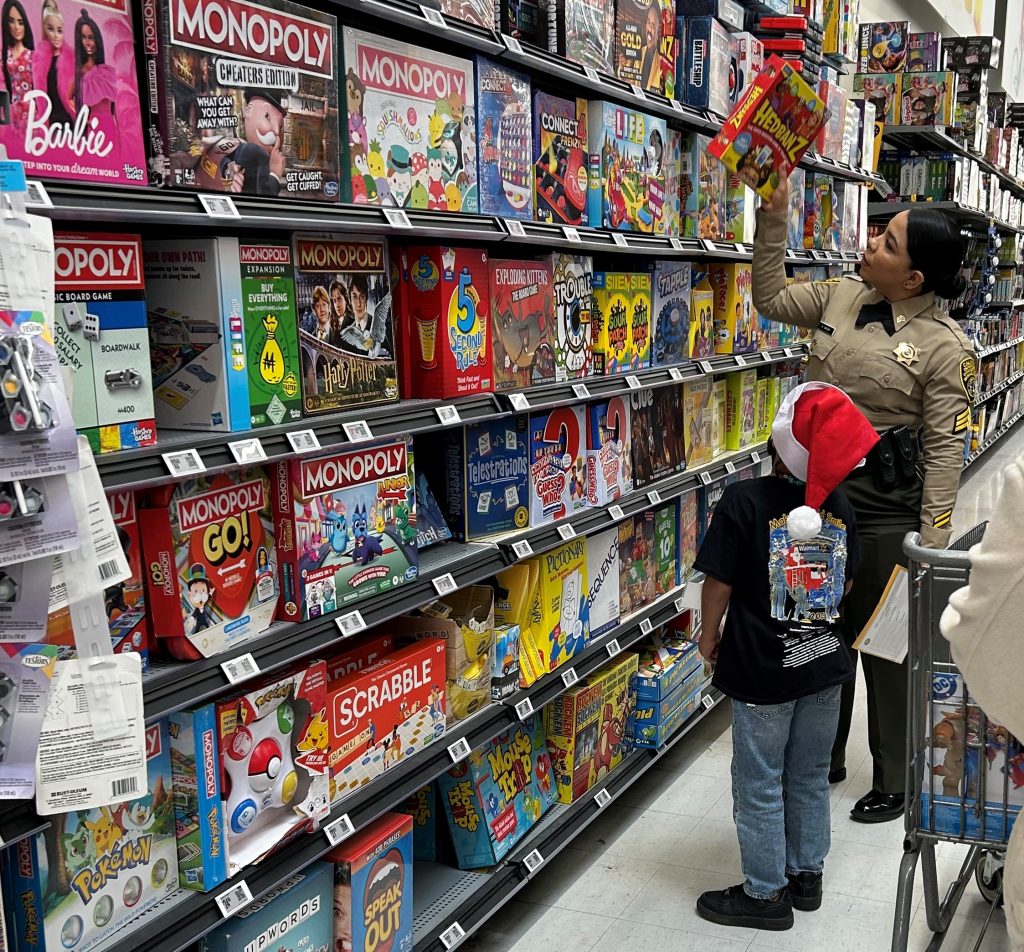 A CIW correctional officer helps a child shop for Christmas holiday gifts.