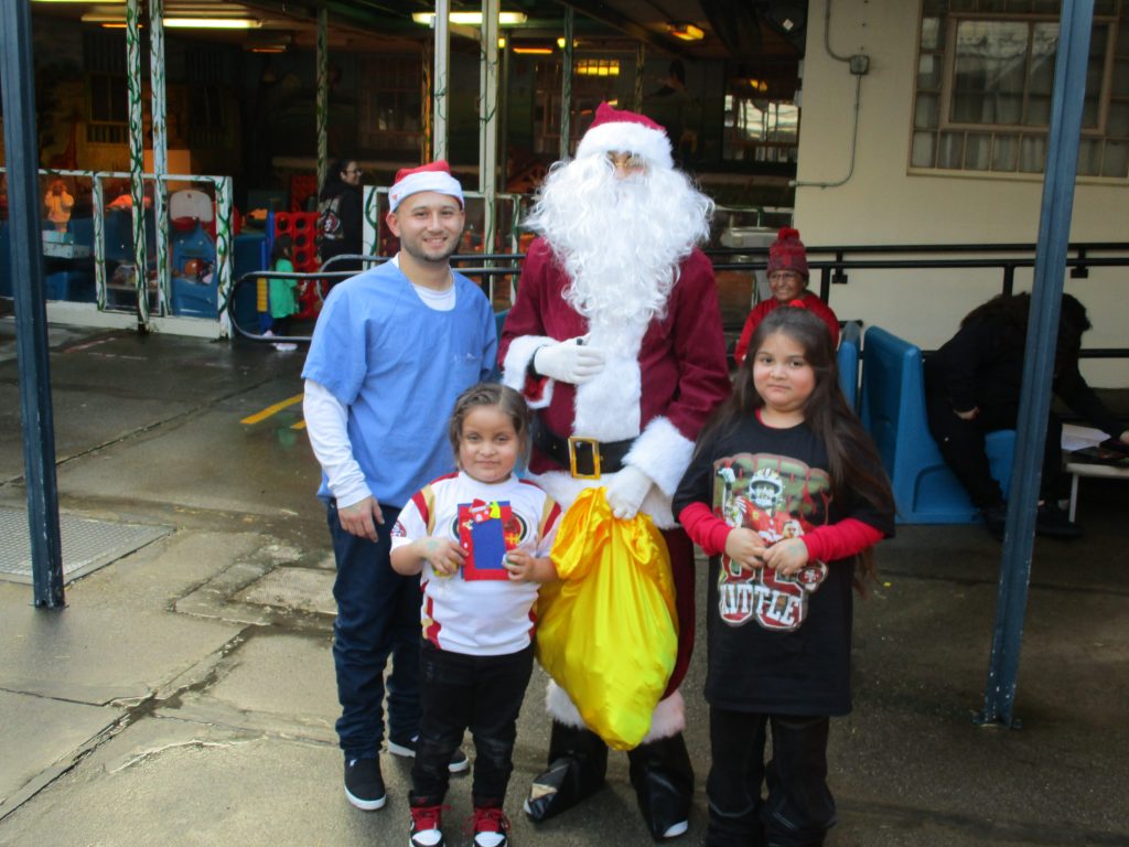 Santa with incarcerated person and children at CMF Christmas visiting. 