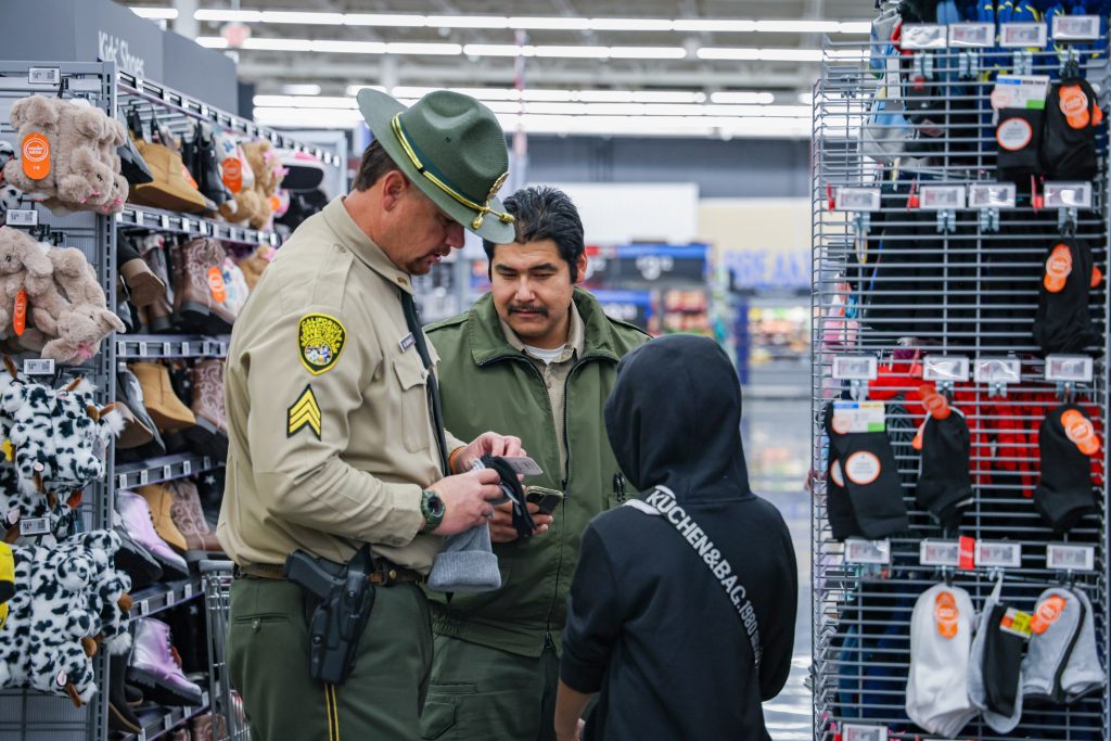 Sergeant and a cadet from the CDCR Richard A. McGee Correctional Training Center in Galt, California, take a child shopping.