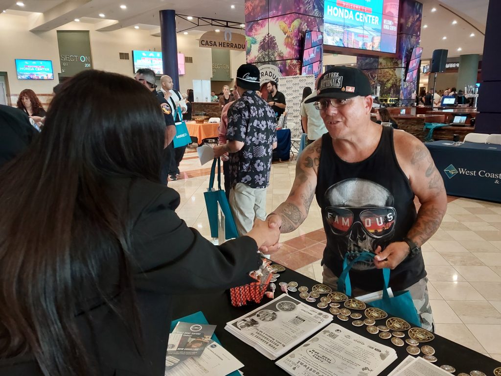 supervised person talking to DAPO staff at booth